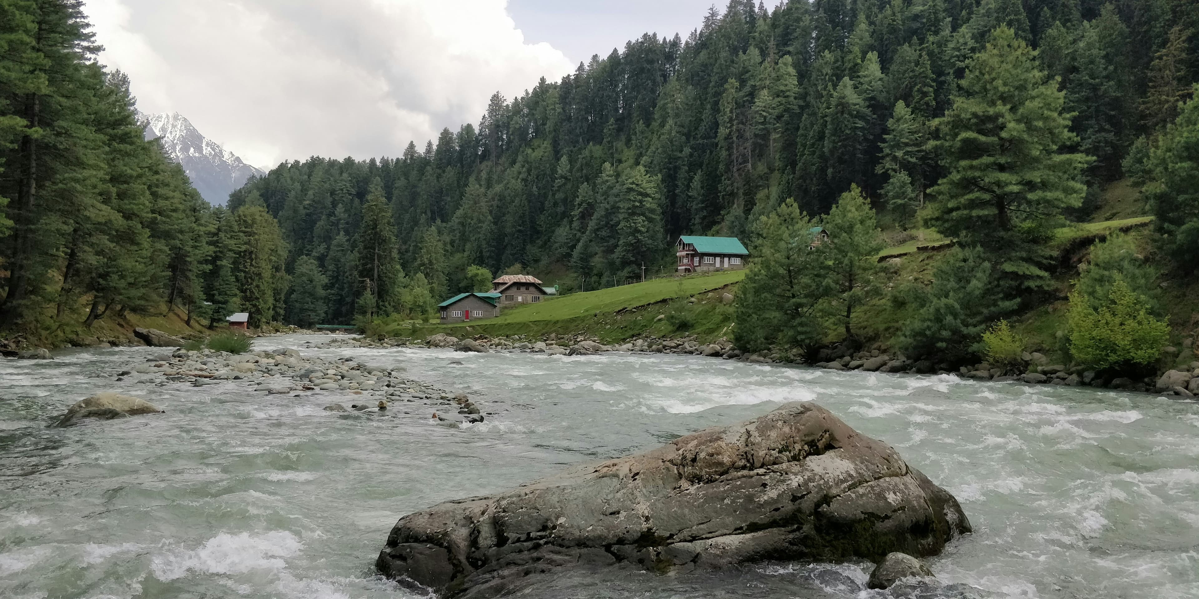 A picturesque landscape of a river flowing through a lush green valley.